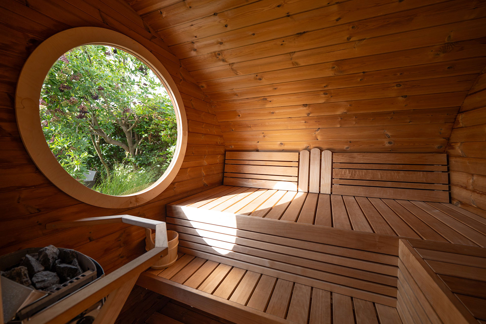Hobbit sauna i træ med rundt vindue fra Sølund Huse